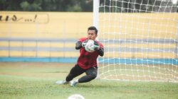 Seorang kiper sepak bola melakukan penyelamatan dinamis selama pertandingan di luar ruangan di Jakarta, Indonesia.
