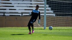 Penjaga gawang menendang bola sepak pada hari yang cerah selama pertandingan latihan.