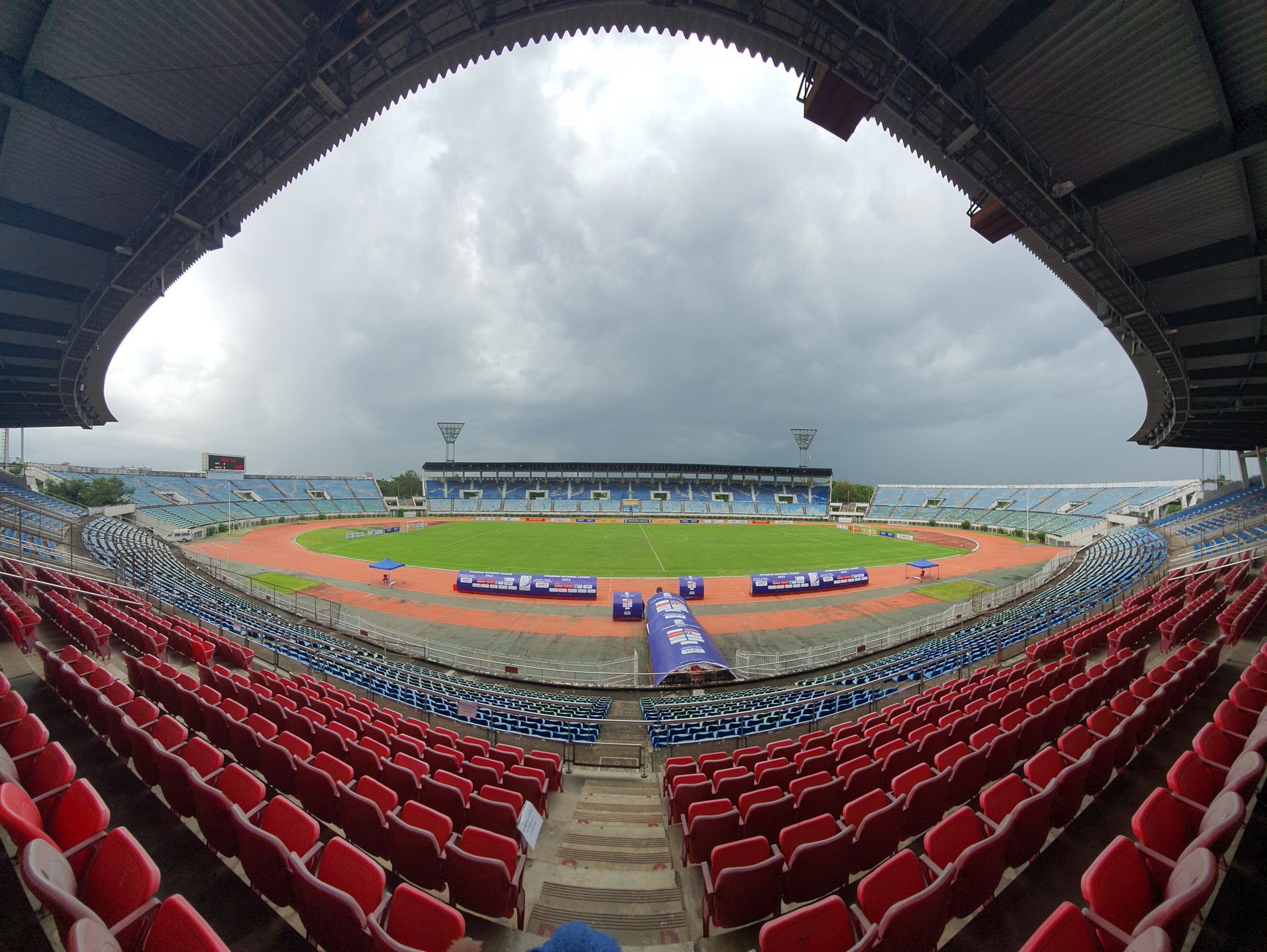 Pandangan sudut lebar dari stadion olahraga di Yangon, Myanmar dengan awan hujan di atas.
