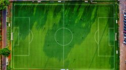 Foto drone lapangan sepak bola di Jakarta, Indonesia dengan pemain yang berlatih.