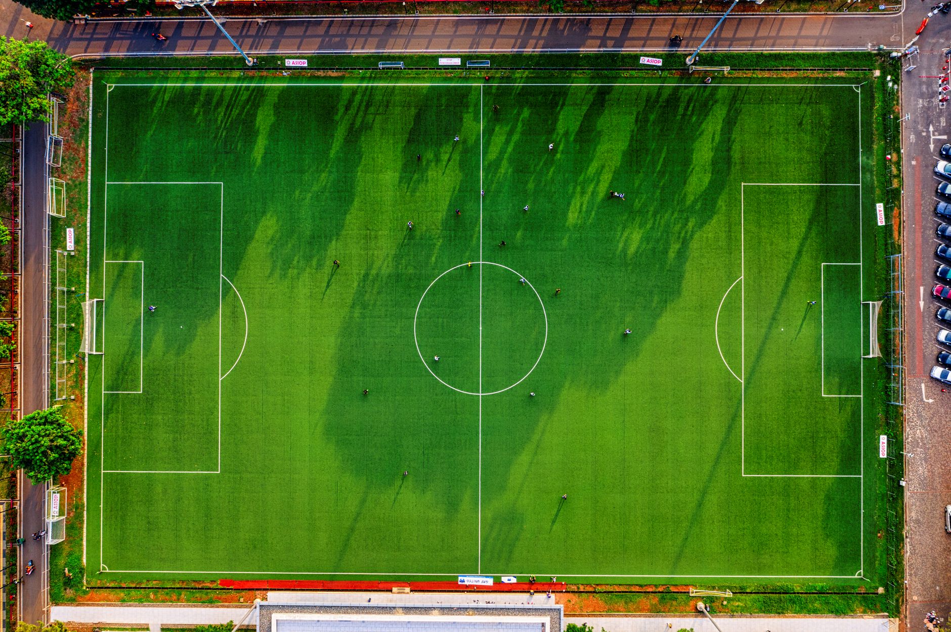 Foto drone lapangan sepak bola di Jakarta, Indonesia dengan pemain yang berlatih.