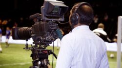 Sebuah kameramen yang merekam pertandingan sepak bola di stadion, menangkap aksi dalam video.