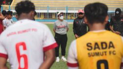 Tim sepak bola berkumpul dalam huddle di lapangan terbuka di Jakarta, Indonesia.