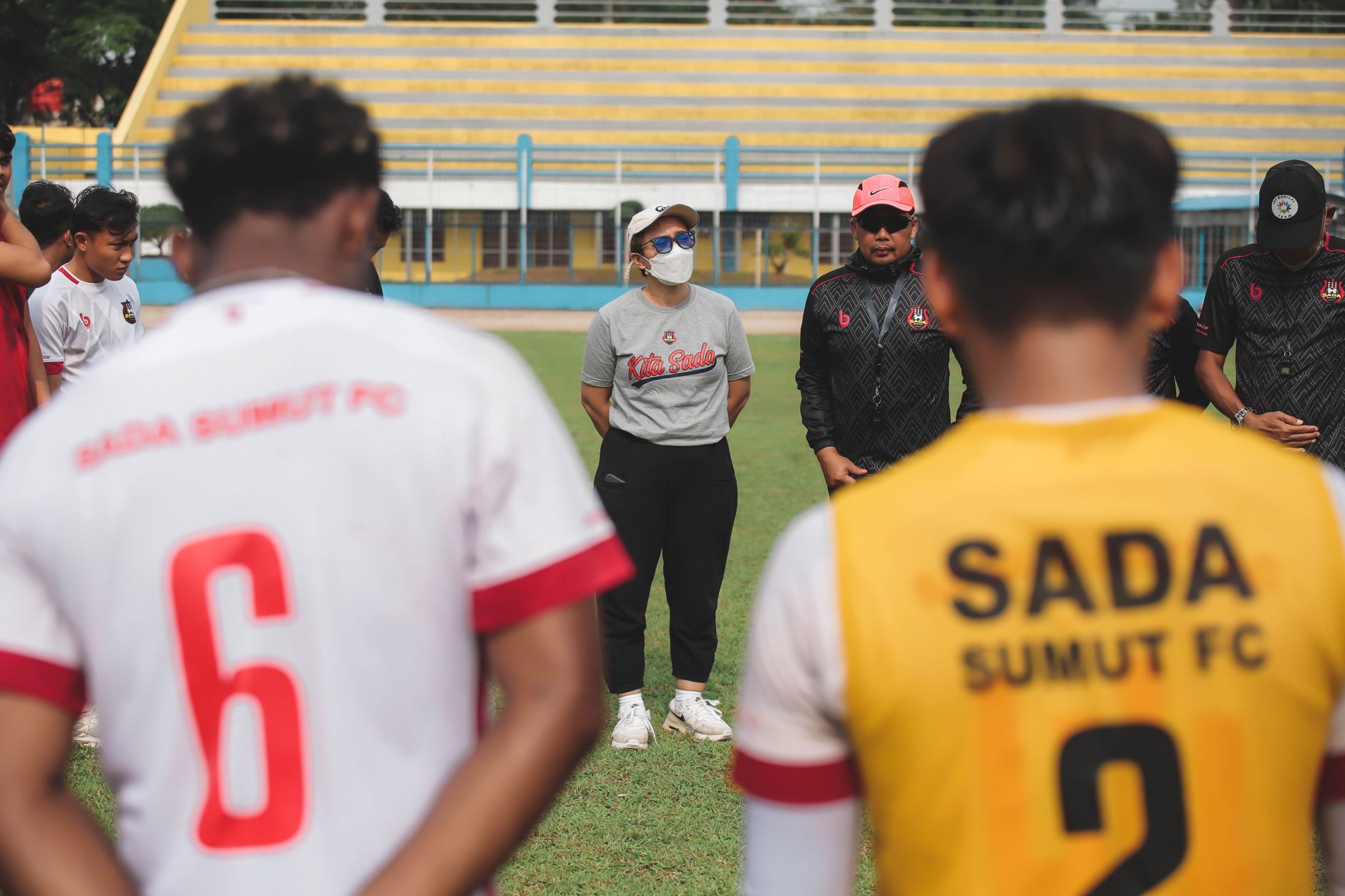 Tim sepak bola berkumpul dalam huddle di lapangan terbuka di Jakarta, Indonesia.