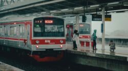 Para penumpang di stasiun Bogor menaiki kereta api pada hari hujan, Indonesia.