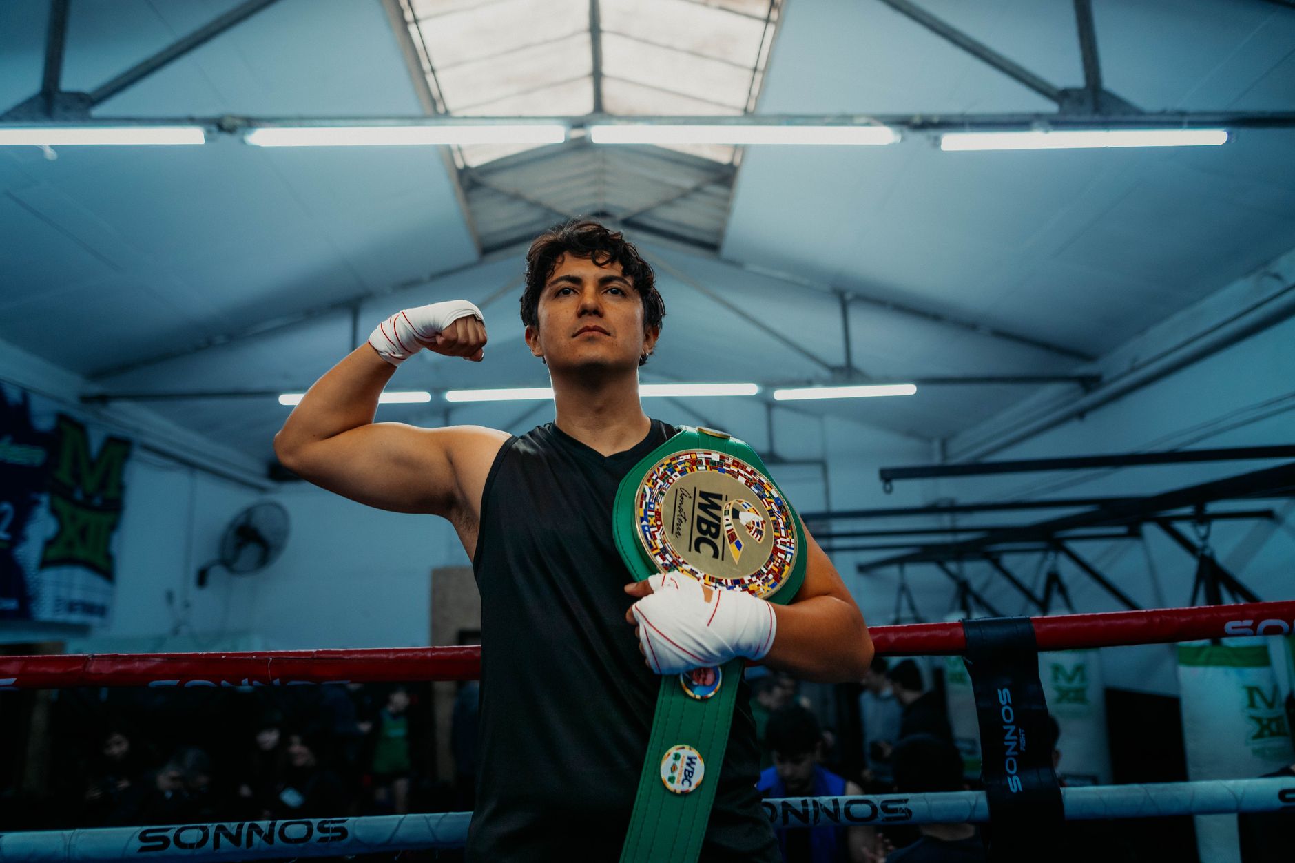 Petinju dengan bangga memegang sabuk kejuaraan di dalam pengaturan gym.