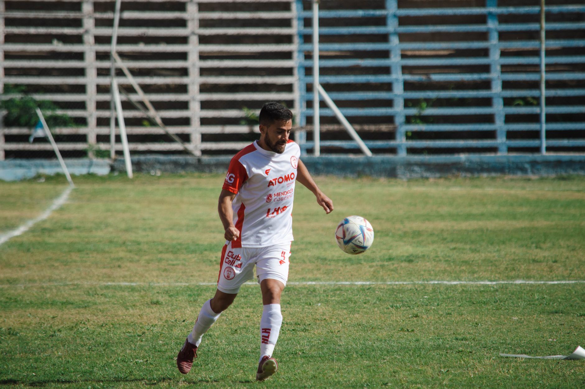 Pemain sepak bola dengan seragam putih bermain di lapangan di Mendoza, Argentina.