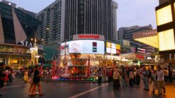 Suasana malam yang meriah di Fahrenheit 88 di Kuala Lumpur dengan keramaian yang hidup dan lampu-lampu kota yang terang.