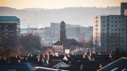 Pemandangan kota Bristol menampilkan Gereja St Luke di tengah gedung-gedung kota saat matahari terbenam dengan tenang.