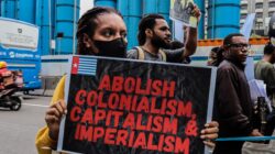 Aktivis di Jakarta memprotes kolonialisme, kapitalisme, dan imperialisme.