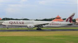 Pesawat Qatar Airways yang menampilkan logo Piala Dunia FIFA 2022 mendarat di landasan.