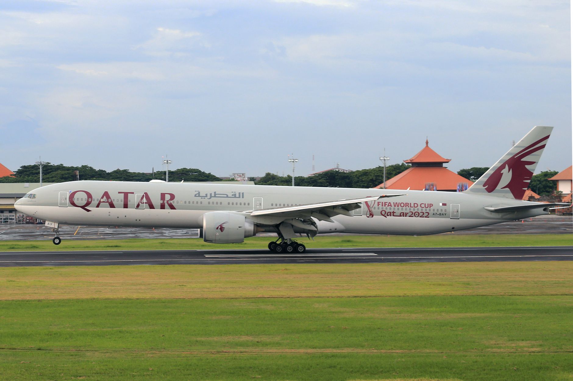 Pesawat Qatar Airways yang menampilkan logo Piala Dunia FIFA 2022 mendarat di landasan.