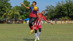 Dua pemain sepak bola muda bersaing ketat untuk merebut bola di lapangan terbuka.
