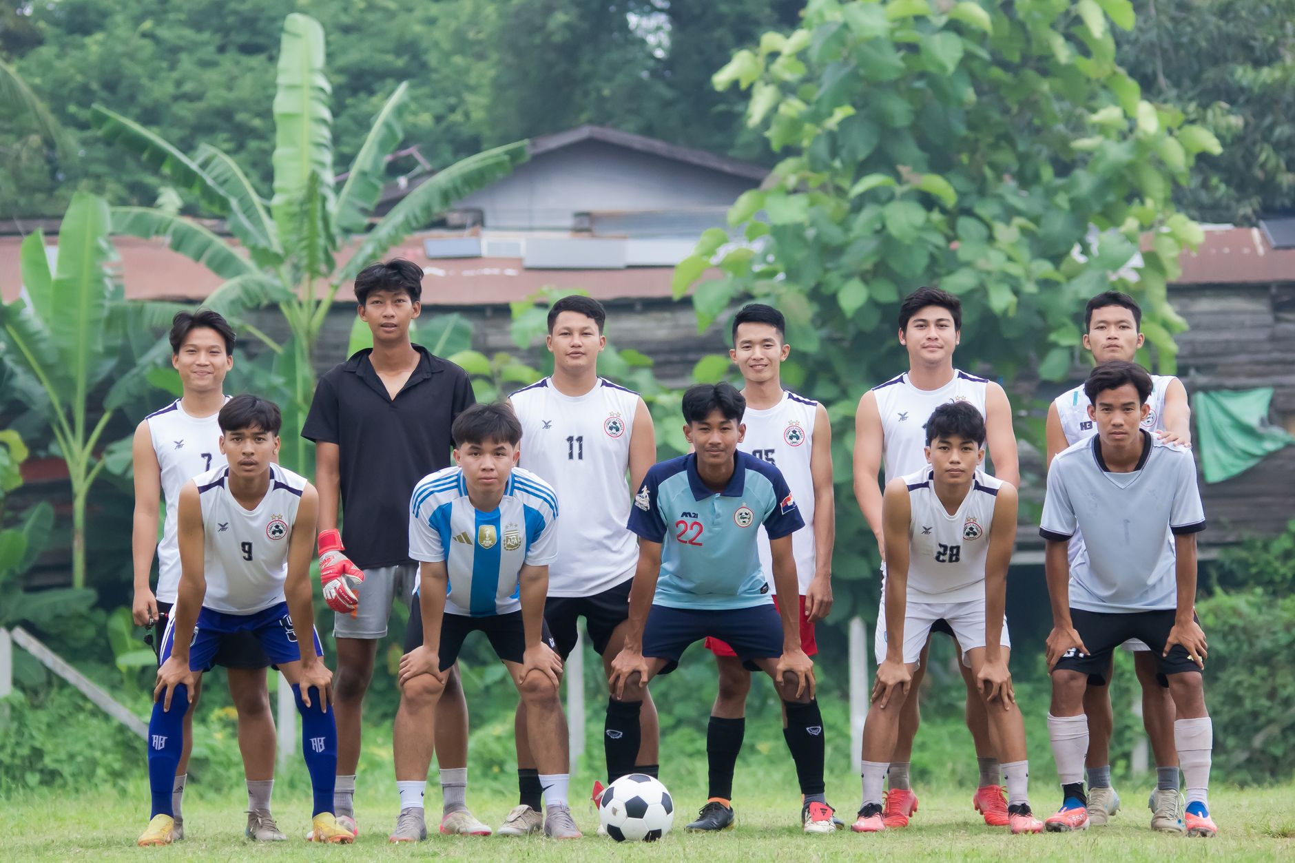 Sebuah tim sepak bola lokal berpose di luar ruangan untuk foto grup di Myawadi, Myanmar.