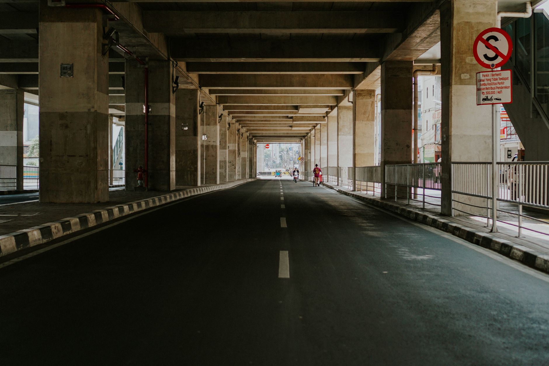 Pemandangan jalan bawah tanah perkotaan yang kosong dengan tanda jalan di Jakarta, Indonesia.