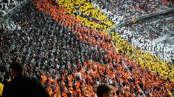 Bagian penggemar yang penuh warna menciptakan pola yang mencolok di stadion di Munich.