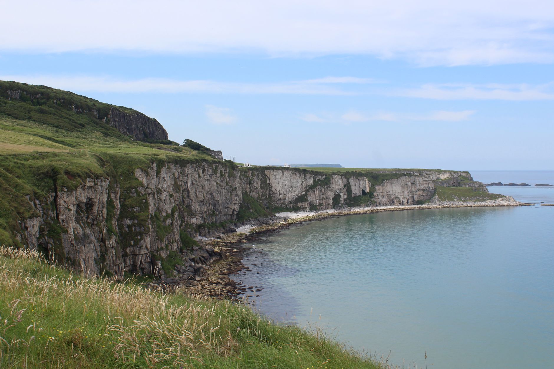 Tebing pantai yang indah di bawah langit cerah di Irlandia Utara.