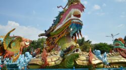 Patung naga yang semarak di taman terbuka, menampilkan detail yang rumit dan warna-warna cerah.