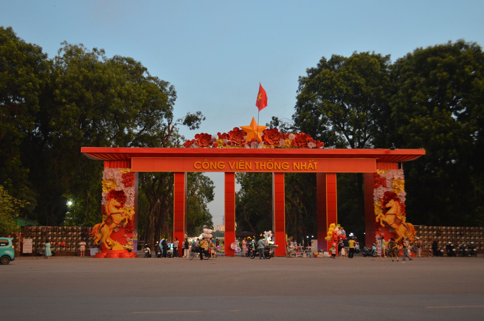 Pemandangan senja dari pintu masuk yang ramai di Cong Vien Thong Nhat di Hanoi, Vietnam.
