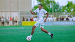 Seorang pemain sepak bola beraksi selama pertandingan, memamerkan keterampilannya di lapangan hijau.