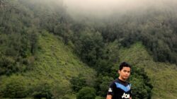 Pemandangan berkabut yang tenang dengan seorang pria dewasa berdiri di Klojen, Indonesia.