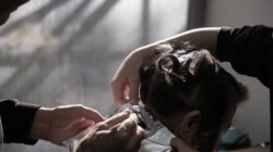 Penata rambut ahli mengaplikasikan highlight warna di salon dengan pencahayaan alami di İzmir, Türkiye.
