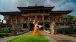 Seorang penari tradisional yang energik menampilkan pertunjukan di depan sebuah bangunan bersejarah di Jakarta, Indonesia, memperlihatkan keanggunan budaya.