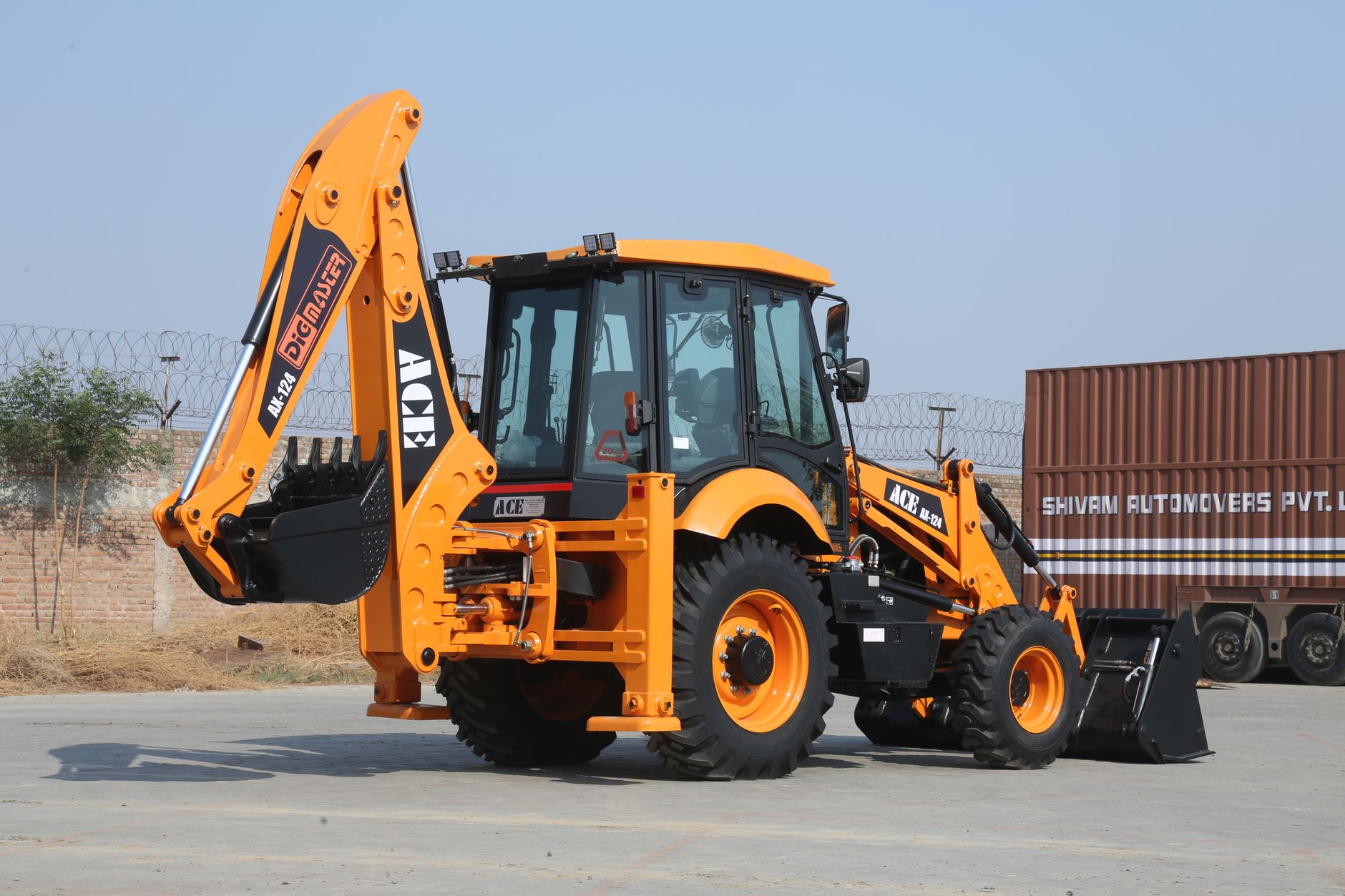 Backhoe loader ACE AX 124 pada hari yang cerah di lokasi konstruksi Faridabad.