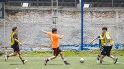 Pertandingan sepak bola yang energik dengan pemain amatir di lapangan terbuka yang cerah di Kota Meksiko.