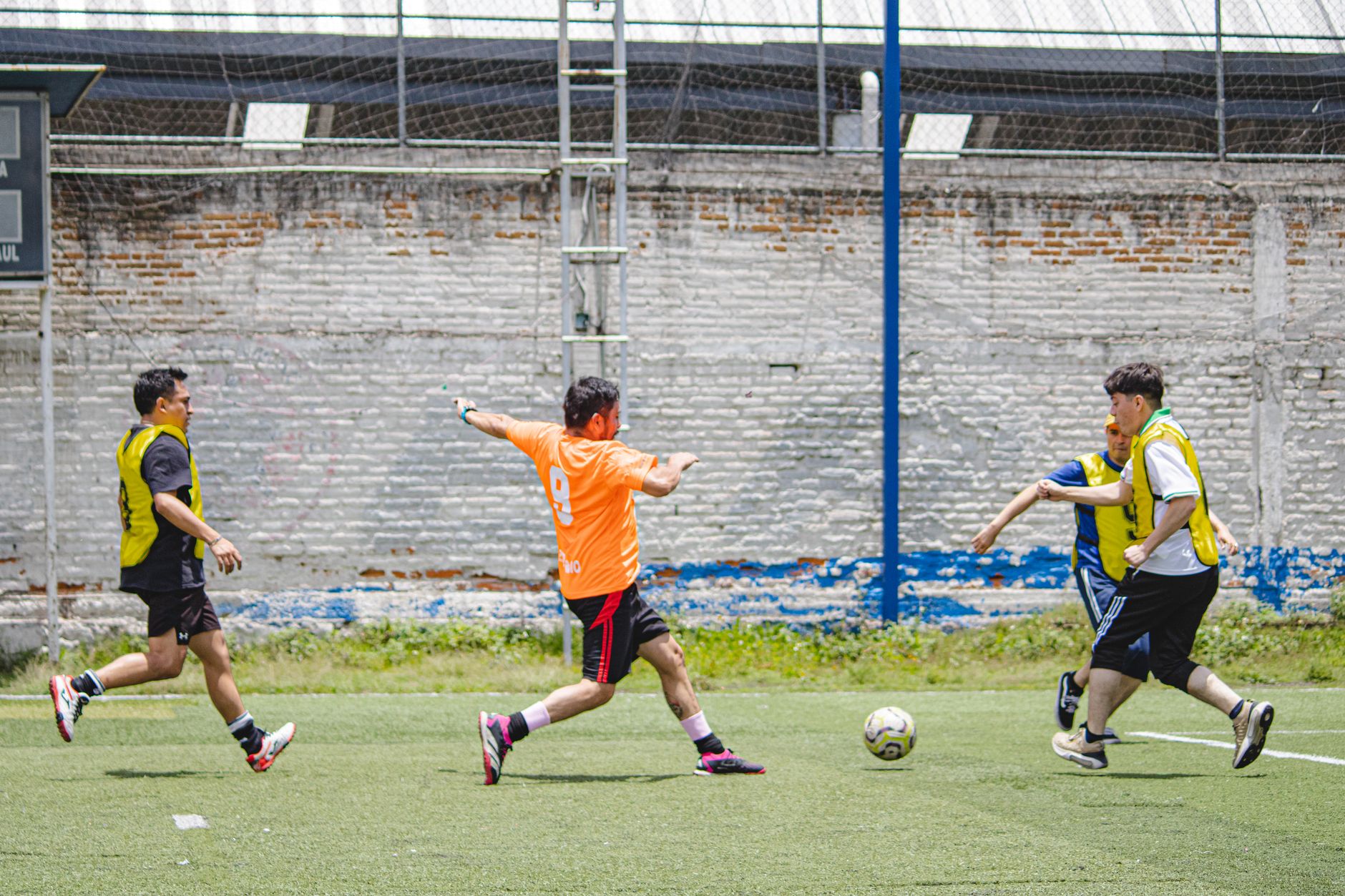 Pertandingan sepak bola yang energik dengan pemain amatir di lapangan terbuka yang cerah di Kota Meksiko.