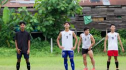Sekelompok pemuda bersiap bermain sepak bola di lapangan hijau yang subur di Myawadi, Myanmar.