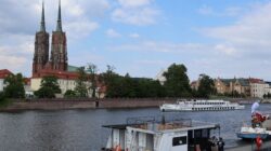 Pemandangan indah Pulau Katedral Wrocław dengan sebuah perahu di Sungai Oder.