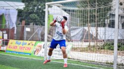 Seorang penjaga gawang melakukan penyelamatan selama pertandingan sepak bola di lapangan rumput buatan di Hanoi, Vietnam.